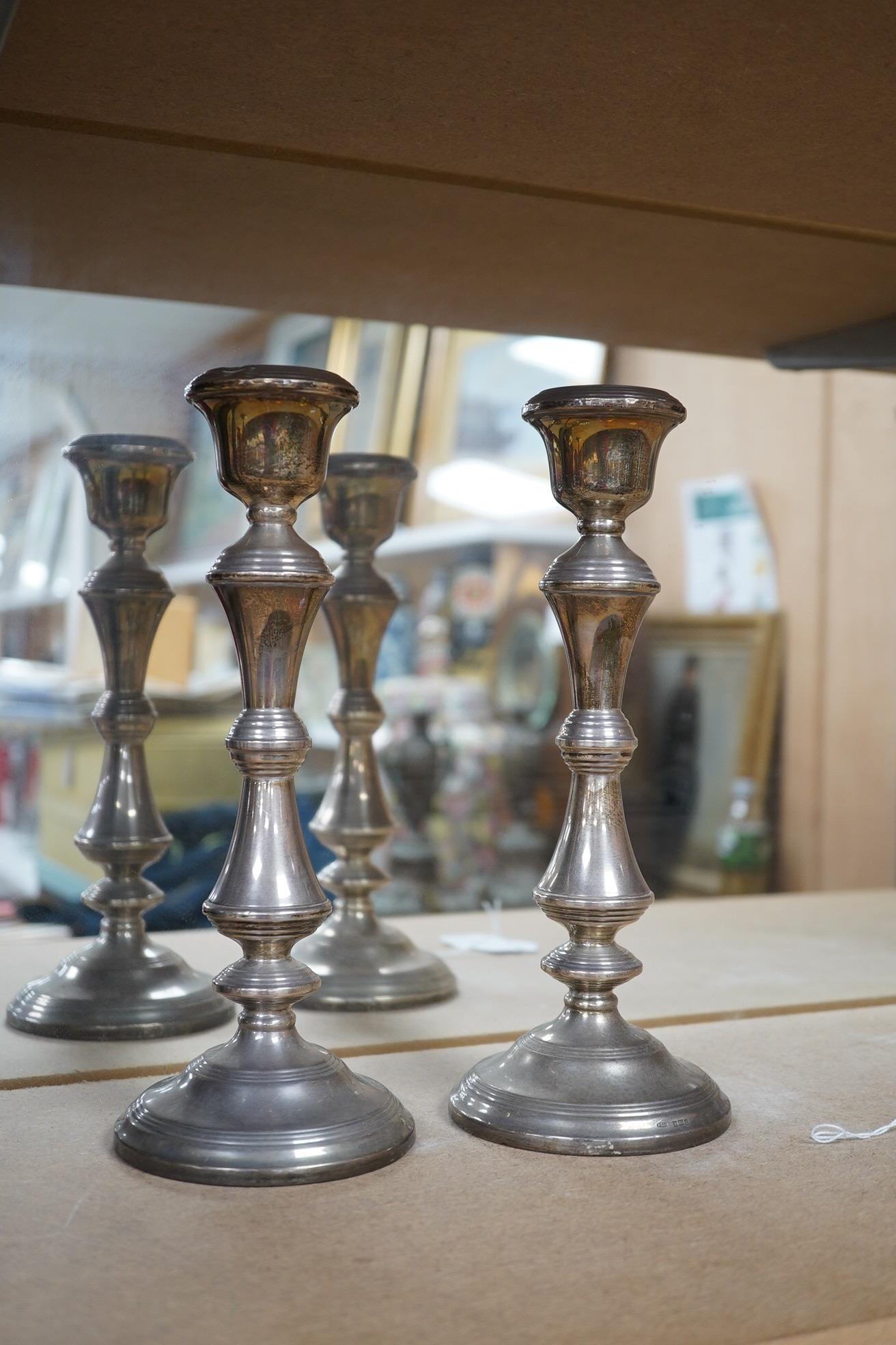 A pair of Elizabeth II silver candlesticks, Broadway & Co, Birmingham, 1960, 25.7cm, weighted, together with a similar silver three light candelabrum, by Adie Bros, weighted. Condition - poor to fair